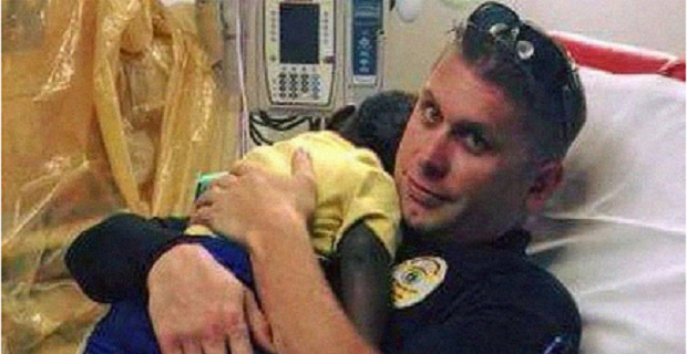 Police officer comforts a scared toddler in the hospital