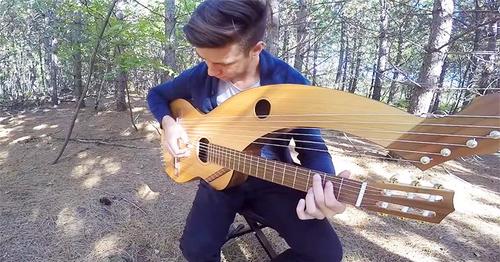 The young man plays literally a magic on 18-string harp guitar…
